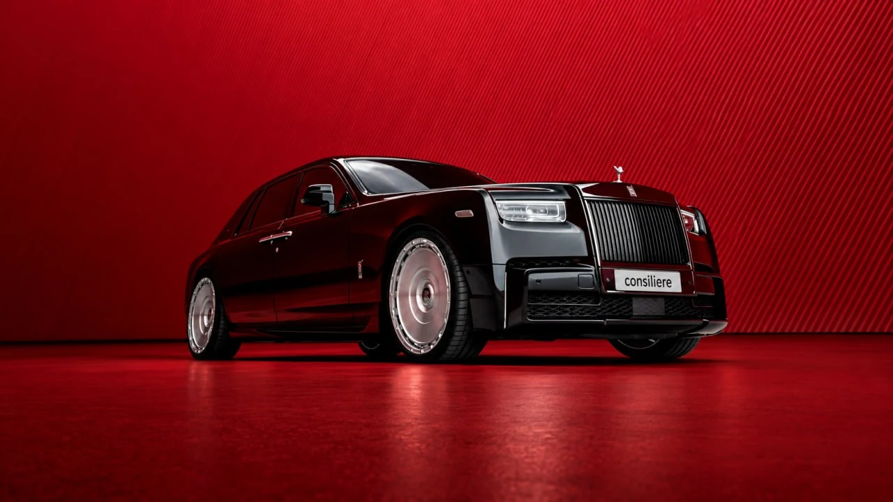 Чёрный Rolls-Royce спереди в три четверти на красном фоне